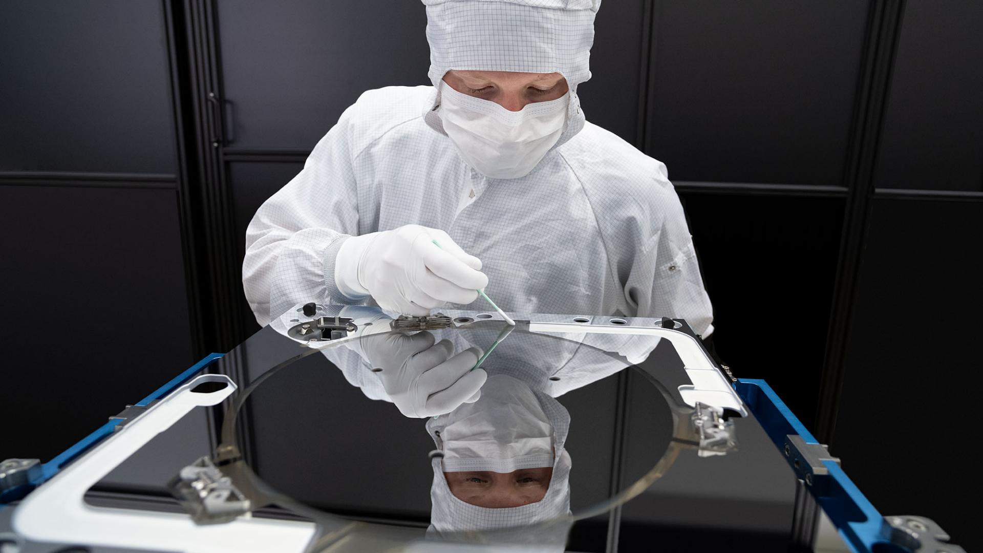 A polished Carl Zeiss EUV mirror, an optical component finished to atomic smoothness, reflecting a faint pattern under clean-room lighting.
