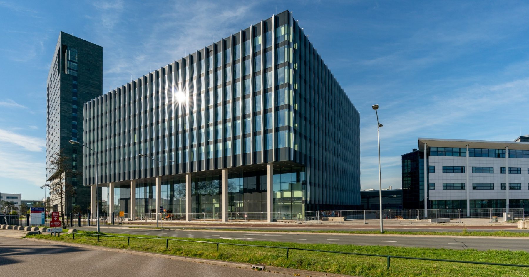 An aerial view of the ASML campus in Veldhoven, Netherlands, a cluster of large modern buildings surrounded by flat green Dutch countryside.