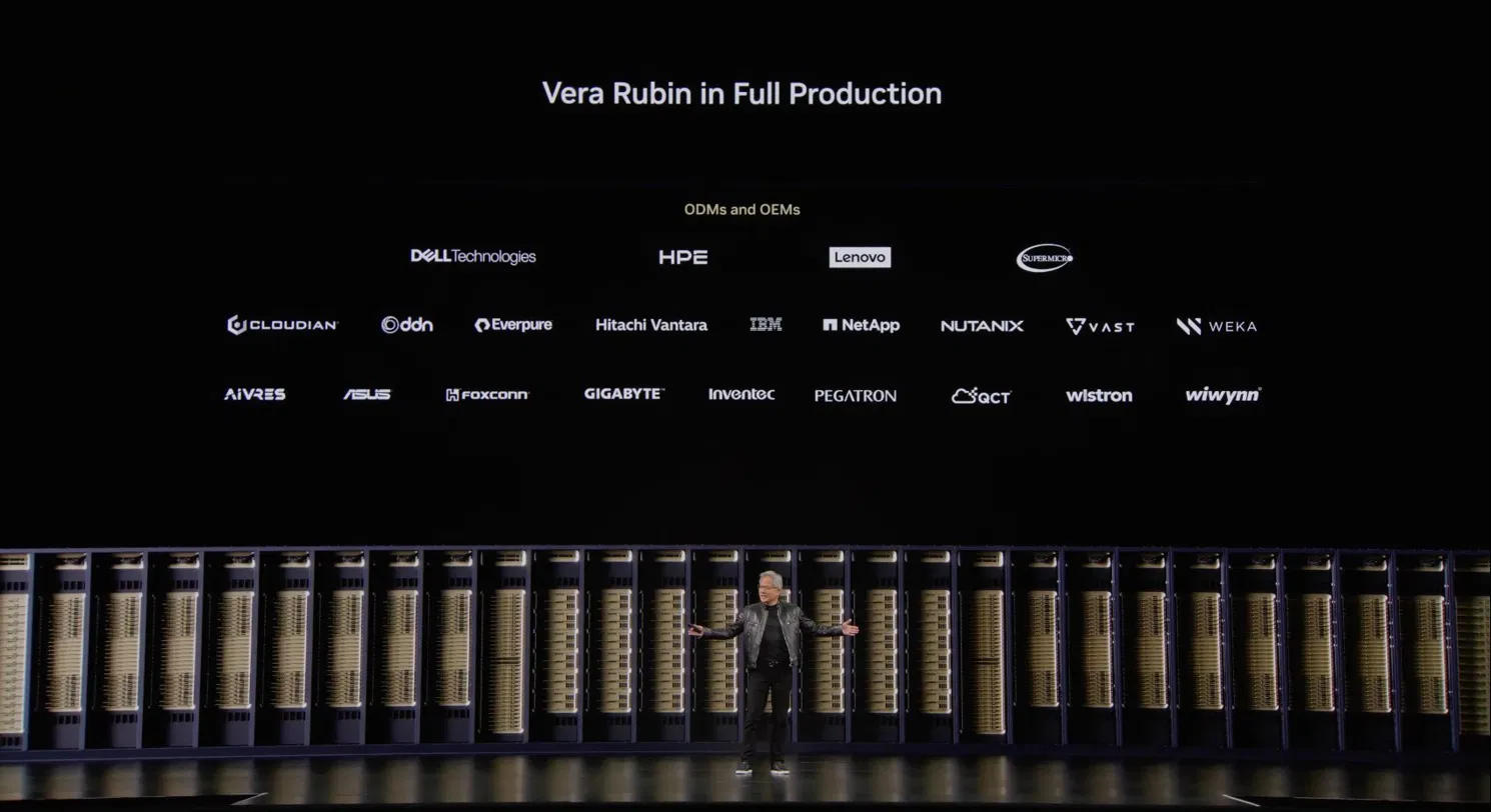 Computex 2026 keynote slide titled Vera Rubin in Full Production, listing ODM and OEM partners including Dell Technologies, HPE, Lenovo and Supermicro, with Jensen Huang on stage in front of a long row of Vera Rubin server racks.